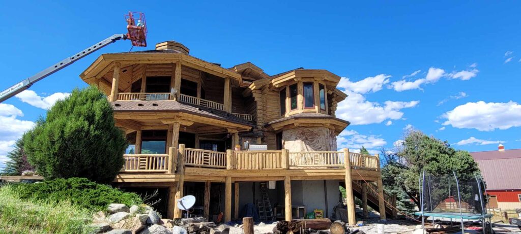 Media blasting the stain off the third story log home to show some of the hazards of log home restoration and maintenance and why it can be expensive.